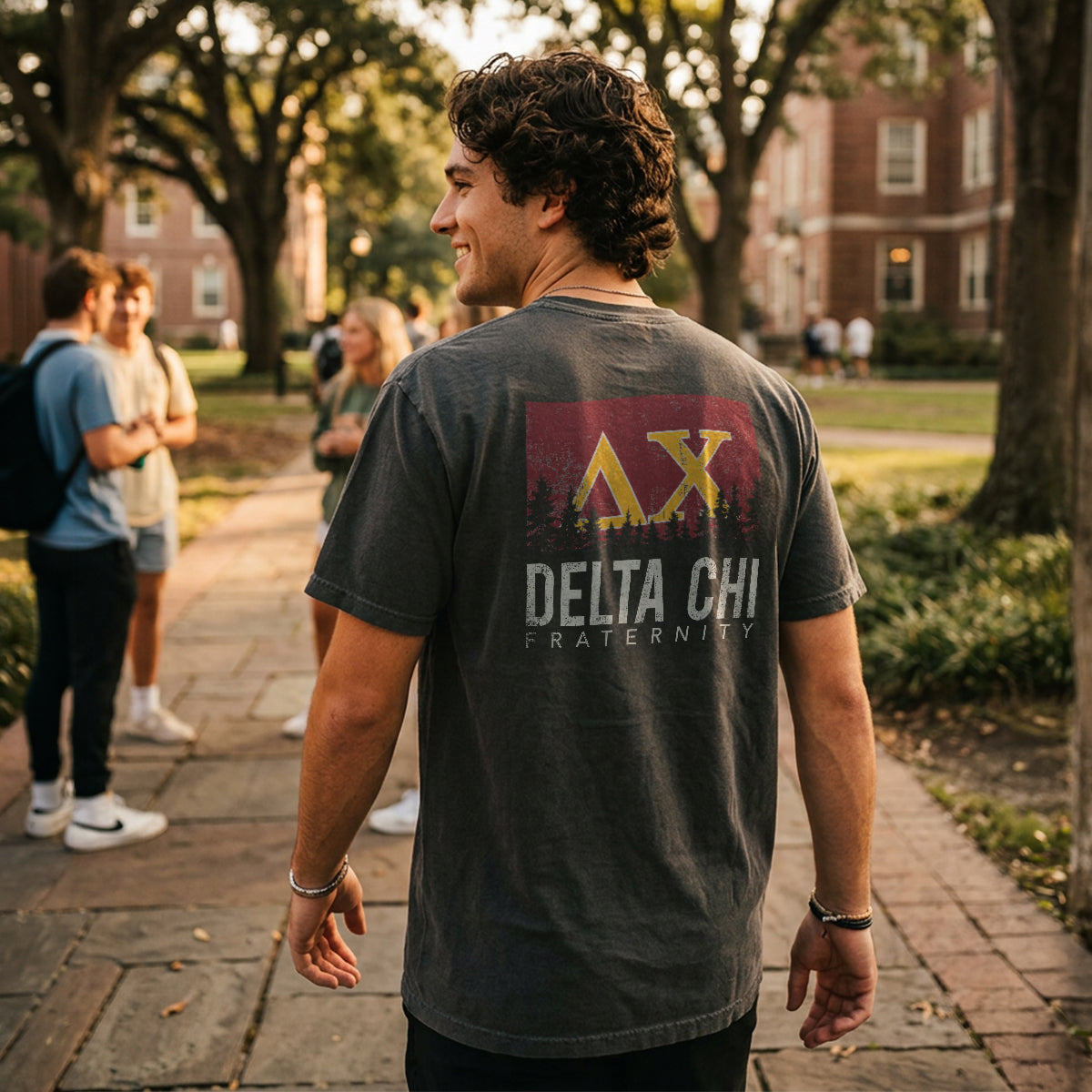 College student wearing fraternity grey t-shirt with colorful flag design on back