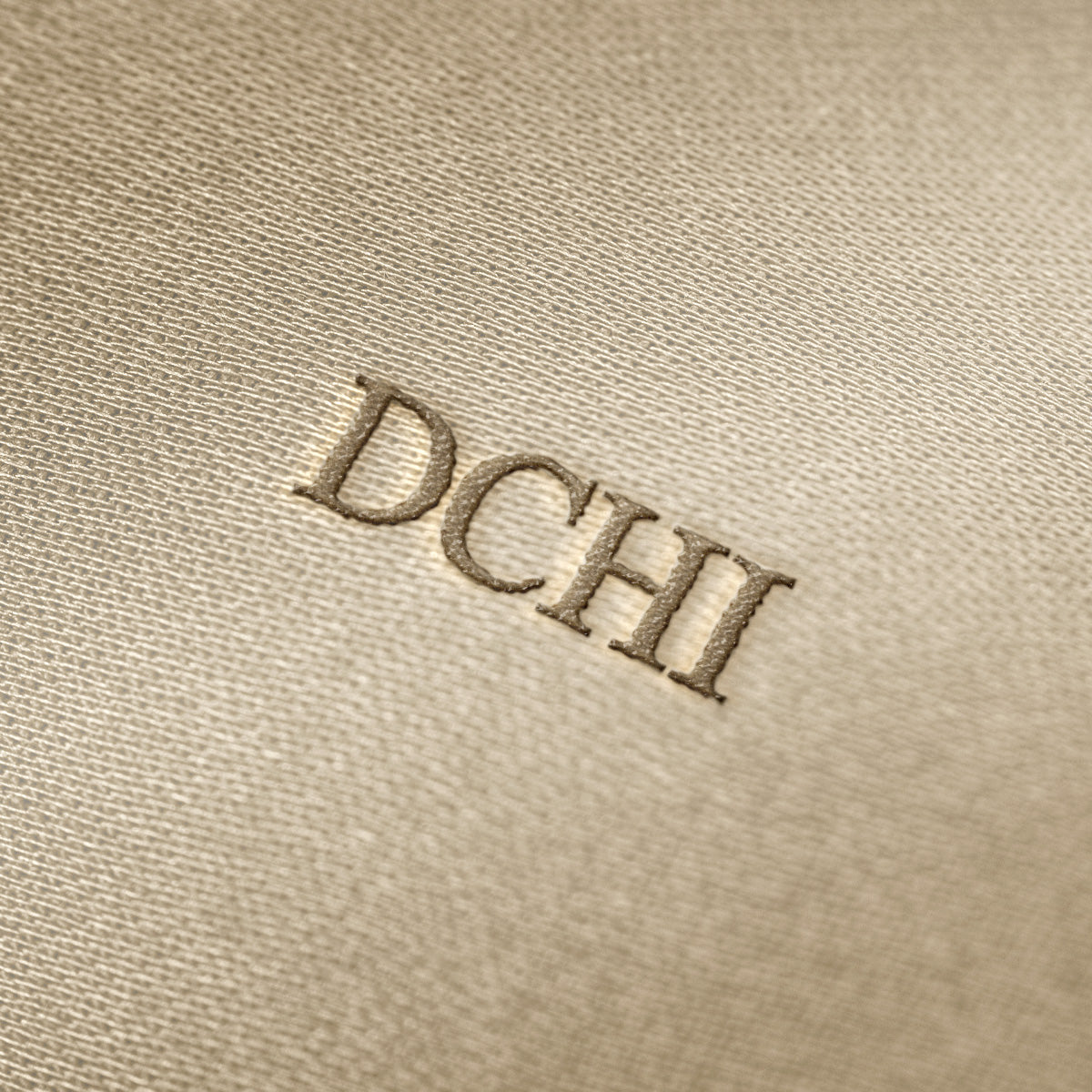 Soft beige fabric close-up showing a smooth, heavyweight knit texture with gentle folds and subtle draping.